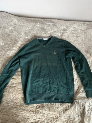 Mörkgrön V-ringad tröja Lacoste - Mörkgrön V-ringad tröja från Lacoste. Perfekt för att ha lager på lager. 