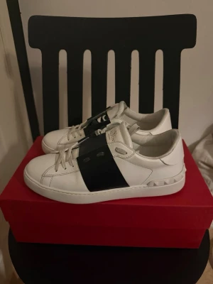 Valentino Garavani vita sneakers - Säljer ett par vita Valentino Garavani sneakers i storlek 40 men passar även 41! Skorna är i bra skick samt äkta, finns kvitto och nya snören samt skopåsar till vardera sko. Köpte skorna för runt 5700kr från merchsweden.  Säljer skorna eftersom jag känner att jag behöver något nytt.