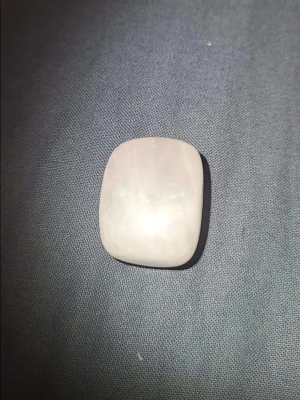 Rundad ljusrosa sten - Säljer en polerad, fyrkantigt rundad ljusrosa sten som kan användas som dekoration eller smyckesdetalj. Stenen har en mjuk, blank yta och en subtil pastellfärg som ger ett stilrent intryck.