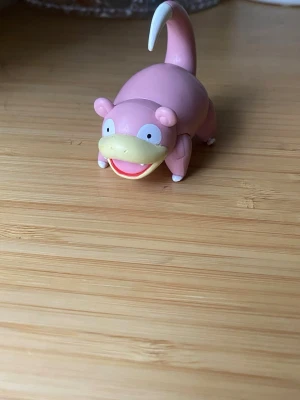 Slowpoke Pokémon figur - Säljer en söt Slowpoke Pokémon figur. Figurer är rosa med ljusgul nos och vit svanstipp. Perfekt för samlare eller som dekoration till skrivbordet.