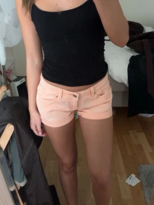 Aprikosfärgade Lågmidjade shorts  - I fint skick. Köptes på en marknad i Spanien. Skulle säga att storleken är S/XS men har för mig att det står 38 inuti.