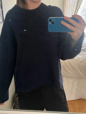 Mörkblå oversized stickad tröja - Mysig mörkblå stickad tröja med avslappnad, oversized passform och rund halsringning. Tröjan har långa ärmar och är tillverkad i ett mjukt, fluffigt material som känns skönt mot huden. Perfekt för lager på lager och en chill look.