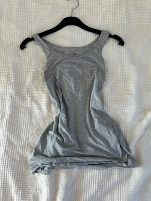 Grå linnetopp från H&M - Säljer en enkel och stilren grå linnetopp från H&M. Toppen är ärmlös med rundad halsringning. Perfekt att matcha med jeans eller kjol för sommaren.💕