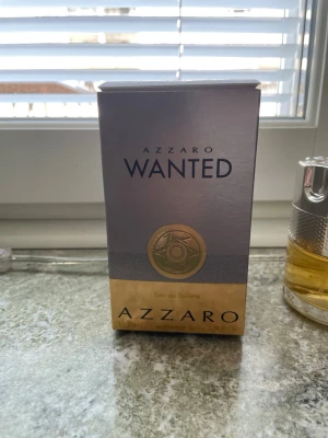 Azzaro Wanted Eau de Toilette - Azzaro Wanted Eau de Toilette är en parfym för honom med en lyxig flaska i silver och glas, fylld med gyllengul vätska. Doften kommer i en snygg förpackning med guld- och silverdetaljer. Perfekt för dig som gillar eleganta och maskulina dofter.