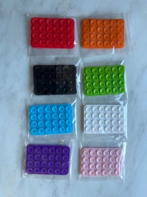 Sugpropp till mobil – 8 st (dubbelsidiga, flera färger) -  Säljer 8 st dubbelsidiga sugproppar för mobil i olika färger (se bild). Perfekta för att fästa mobilen på spegel, kakel eller glas – populära för TikTok och video.  • Antal: 8 st • Skick: Nya, oöppnade • Färger: Blandade • Dubbelsidiga – enkla att flytta mellan mobil och olika ytor • Passar alla mobiler  Säljes som paket. 