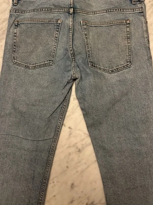 Ljusblå raka jeans  - Säljer ett par ljusblå jeans raka ben. Jeansen har normal midja, bälteshällor och dragkedjegylf. Perfekta till en avslappnad stil och passar till det mesta. Materialet är denim i bomull. W34 L32