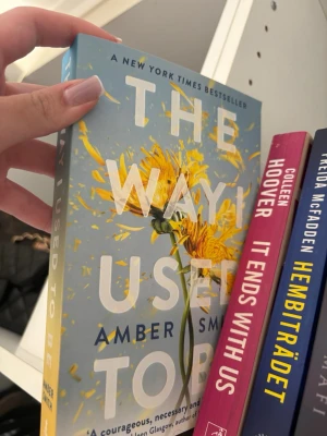 The Way I Used To Be av Amber Smith - En gripande roman med blått omslag och en gul maskros i centrum. Titeln är tryckt i stora vita bokstäver. Perfekt för dig som gillar känslosamma och tankeväckande berättelser. Pocketbok med mjukt omslag.