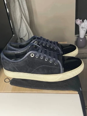 Lanvin skor  - Säljer ett par riktigt fräscha lanvins skor i marinblå färg pytte lite slitet under skon som ni kan se på bilden storlek 42 men sitter bra på mig med 43 tveka inte på att skriva finns en liten skada som ni kan se på sista bilden!!!!!