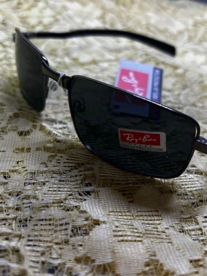 Svarta solglasögon från RoyBon - Snygga svarta solglasögon från RoyBon med rektangulära glas och metallbågar. Glasen är mörka och ger 100% UV-skydd. Perfekt accessoar för att lyfta din stil under soliga dagar.