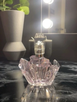 Ariana Grande R.E.M parfym - Säljer en Ariana Grande parfym i en ljusrosa, kristallformad glasflaska. Luktar femenimt, lavendel och passar till alla tillfällen 💜