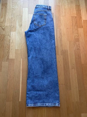 My essential wardrobe jeans  26 - Säljer ett par My essential wardrobe jeans med rak och bred passform i fint skick . Jeansen har klassisk femficksdesign och stängs med knapp och dragkedja. Materialet är kraftig denim i bomull. Perfekta för en avslappnad och trendig look.