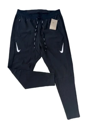 Svarta Nike aeroswift byxor- Strl-M/junior - Svarta mjukisbyxor från Nike med vita loggor på båda sidor framtill. Byxorna har dragsko i midjan, ribbade muddar vid bensluten och dragkedjefickor. Perfekta för en sportig och avslappnad stil.                      Passform: M men kan även passa för personer som bär lite större strl.