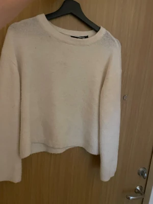 Vit stickad tröja - Mysig vit stickad tröja med rund halsringning. Tröjan har en rak och något kortare passform med ribbstickade muddar vid ärmslut och nederkant. Perfekt för lager-på-lager och enkel att matcha med olika outfits. I storlek S.