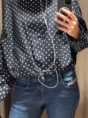 Mörkblå prickig jacka - Snygg mörkblå jacka med vita prickar och hög krage. Jackan har avslappnad passform, långa ärmar och snöre i nederkanten. Storlek XL men passar som s-xs. Prislapp kvar 