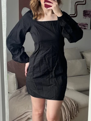Svart kort klänning med puffärm - Säljer en svart kort klänning med fyrkantig urringning och långa puffärmar. Klänningen har en figurnära passform och är tillverkad i ett tunt, lätt material som ger en snygg siluett. Perfekt för dig som vill ha en enkel men trendig look.