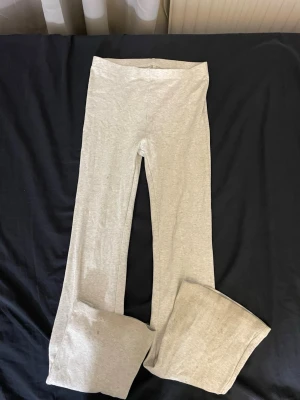 Grå bootcut leggings - Ljusa grå leggings med bootcut-ben och hög midja. Mjukt och stretchigt material som sitter skönt på kroppen. Perfekta för en avslappnad och trendig look.