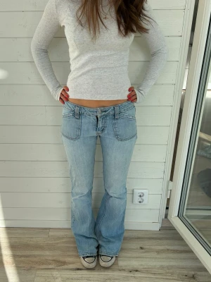 Ljusblå jeans  - Ljusblå jeans från Guess i storlek S. Har flera slitage på baksidan och vid foten, samt saknar en knapp på bakfickan. Midjemått: 38x2 cm innerbenslängd: 80 cm