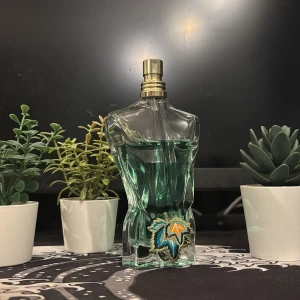 Paradis garden JPG - Ikonisk parfymflaska formad som en manlig torso med grönt innehåll och broderad detalj med lövmotiv. Mängd enligt bild kvar, kontakta vid mer frågor😀