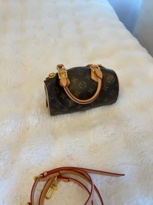 Väska  - Snygg handväska i klassiskt brunt monogrammönster med ljusa läderdetaljer och guldfärgade metalldelar. I super bra skick 