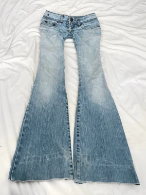 Ljusblå lågmidjade bootcut  jeans med slitningar - Sååå sjukt snygga vintage superlågmidjade jeans bootcut jeans! Säljer eftersom dem inte passar därför har jag ingen bild på😩😩🙏🏼🙏🏼😭 Midjemått: 36 cm Innebenslängd: 78 cm! 