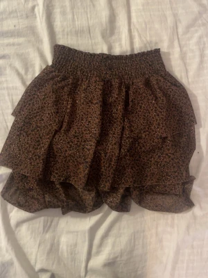 Söt leopard kjol - Jättefin brun leopard kjol med guldiga små prickar. Den är storlek 9år, men jag skulle säga att den passar som xxs/xs, om man gillar lite kortare kjolar🥰😁 funkar även perfekt som topp.                  