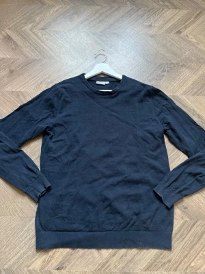 .. - En stilren svart långärmad tröja från Selected Homme. Tröjan har rund halsringning och ribbade muddar vid ärmslut och nederkant. Perfekt för en clean och enkel look. Materialet känns mjukt och bekvämt.