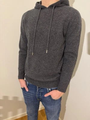 Mörkgrå merinoull hoodie - En extremt snygg merinoulls hoodie i färgen mörkgrå. Storlek S, helt oanvänd! Endast 700kr Hör av dig vid minsta lilla fundering!  