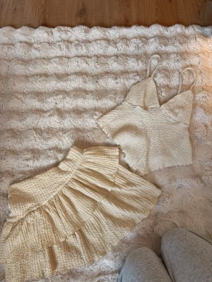 Beige linnetopp med volangkjol - Säljer ett set med en beige linnetopp samt en matchande volangkjol, perfekt till sommaren