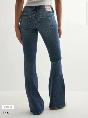 Blå bootcut jeans från True Religion - Snygga blå bootcut jeans från true religion med ikoniska bakfickor med broderad logga. Jeansen har normal midja och är tillverkade i ett stretchigt denimtyg för skön passform. använda få gånger!!! slutsålda!