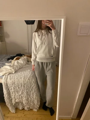 Vit PSG hoodie från Nike - Säljer en vit hoodie från Nike x PSG med huva och dragsko. Hoodien har en halv dragkedja framtill, ficka på magen och elastiska muddar. PSG-logga på bröstet och liten blå Nike Swoosh nedtill. Perfekt för en sportig och chill look.