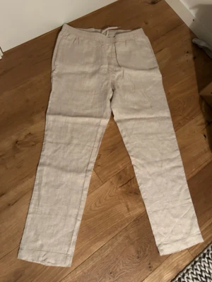 Beige linnebyxor - Snygga beige linnebyxor från hm som är helt oanvända. Säljer dessa eftersom dom inte riktigt passade och har därför inte kommit till användning. Skriv om du har några frågor!