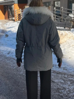 Filippa K dunjacka  - Gröngrå dunjacka från Filippa K med avtagbar vit luva. Är mycket fint skick, enda defekten är ett litet brännmärke på ena ärmen, men syns knappt (har infogat en bild). Sök på Filippa K Oslo Parkas för mer information. Jag är en vanlig S så är true to size. Nypris 4200 kr.