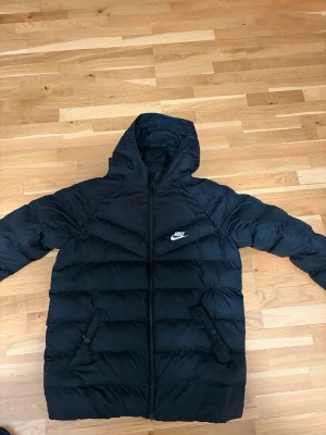 Svart pufferjacka från Nike - Hej, säljer en svart Nike vinterjacka. Den är i storlek 158-170. Passar perfekt till vintern/hösten. Den är i ett jättefint skick och har inga skador eller sådant. Priset kan diskuteras