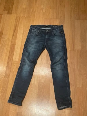 Replay Anbass - Replay Anbass Hyperflex i mörkblå tvätt – den mest populära färgen. Riktigt bra passform och superstretch.  Skick: ✔ Bra skick ✔ Mörk färg — perfekt wash ✔ Ett litet hål Detaljer: • Storlek: W30 L30 • Modell: Anbass • Färg: Mörkblå • Hyperflex-stretch Bilder går att få.
