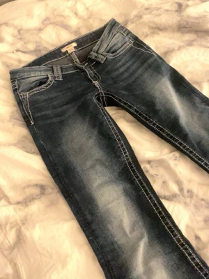Mörkblåa lågmidjade jeans - Mörkblåa lågmidjade jeans från Gina! 😚 har inte använt så mycket men lite slitningar längst ner men det går säkert att sy upp 💕älskar dom verkligen men kan inte ha dom längre tyvärr. Kan skicka bild hur dom sitter på privat! 🥰