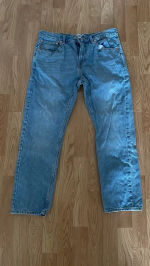 Ljusblå  jeans Lager 157 - Ett par ljusblå jeans från Lager 157 med raka ben och klassisk femficksmodell. Jeansen har kontrastsömmar och är tillverkade i bomull. Perfekta för en avslappnad och trendig look.