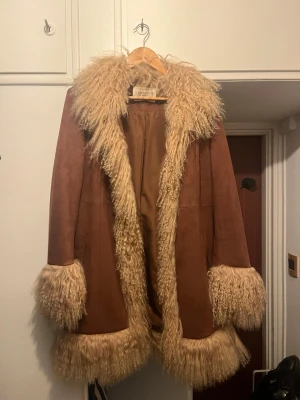 Brun pälskappa från Charlotte Simone - Lulu Coat - äkta pälsdetaljer - storlek XL - nyskick  -  Säljer min Charlotte Simone Lulu coat 🤍 Väldigt sparsamt använd – jättefint skick.  ✨ Äkta mongolisk lammpäls ✨ Ikonisk modell ✨ Sjukt fin på  • Storlek XL (funkar oversize) • Brun/tan färg  Nypris ca 7500 kr  ⚡ Kan säljas snabbt vid smidig affär 💸 Prioriterar snabb affär / upphämtning i Stockholm 📦 Kan även skickas