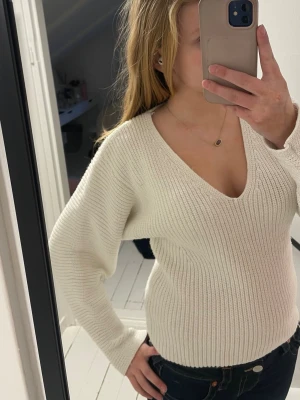 Vit stickad tröja från H&M - En jättefin V-ringad tjocktröja från HM, säljs inte i butik längre så den är lite gammal men har inye varit använd så ofta! 