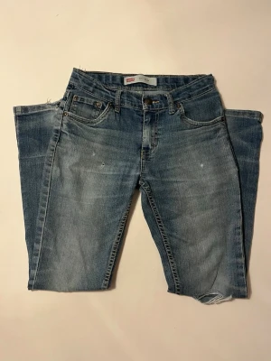Levi's 511 Slim fit jeans - Ljusblå jeans från Levi's med klassisk femficksmodell och raka ben. Jeansen har snygga slitna detaljer och en snygg tvätt. Tillverkade i bomull med dragkedjegylf och knapp. Storlek 152. 