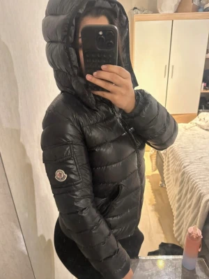 Moncler jacka  - Moncler jacka i modellen bady, sitter som en S jätte skön enda defekten är att den tecknade bilden har lossnat stygn men den sitter fast fortfarande 