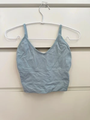 Ljusblå ribbad sporttopp - Ljusblå sporttopp! Den är såå bekväm men blå är inte riktigt min färg 🩵 Sorry för hur skrynklig den är på bilden. Men den är väldigt stretchig i sportmaterial och formar sig fint efter kroppen