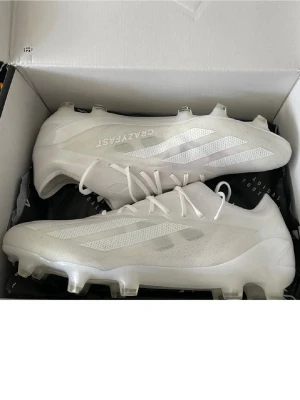  Adidas X Crazyfast elite - Säljer ett par stilrena vita Adidas X Crazyfast Elite fotbollsskor, riktigt fina, använda väldigt lite, några få gånger, annars helt nya. Sälja inte längre i affär. 2800kr nya köptes de. STORLEK 42 2/3 