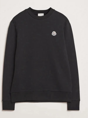 Svart sweatshirt från Moncler - Stilren svart sweatshirt från Moncler med rund halsringning och diskret Moncler-logga på bröstet. Tröjan har långa ärmar, ribbade muddar och är tillverkad i mjukt bomullsmaterial. Perfekt för en avslappnad och trendig look.