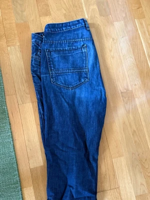 Mörkblå slim jeans Kenneth Cole - Snygga mörkblå slim fit jeans från Kenneth Cole Reaction. Klassisk femficksmodell med dragkedjegylf och kontrastsömmar. Jeansen har en modern passform och är tillverkade i mjukt denimtyg som ger en bekväm känsla hela dagen.