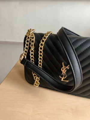 Svart YSL axelväska med guldkedja - Säljer en jättefin väska, buda gärna 🩷