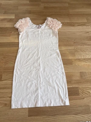 Klänning H&M - Ljusrosa kortklänning från H&M Garden Collection med unika volangärmar i blommig stil. Storlek M.