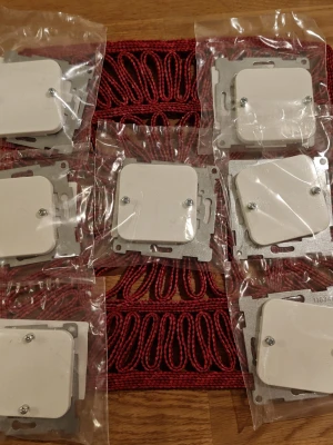 7st. Schneider Electric Centrumplatta Rak Trend SE 51 027 21 - Säljer 7 vita fyrkantiga väggströmbrytare i plast och metall, för infällnad. De är förpackade i plastpåsar och har två synliga skruvar på framsidan. Perfekt till renovering eller byte av strömbrytare hemma.