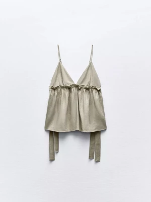 Grön linnetopp med knytband - Snygg grön linnetopp med tunna axelband och v-ringad hals. Toppen har dekorativa knytband i sidorna och en lätt rynkad detalj under bysten för en avslappnad look. Perfekt för varma dagar och enkel att styla med jeans eller kjol.