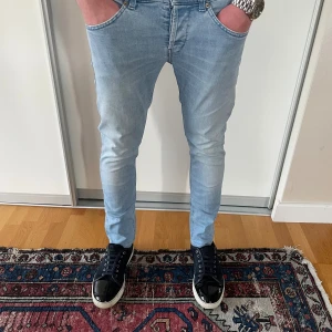 Ljusblå dondup George jeans med slitningar  - Säljer ett par feta ljusblåa dondup George jeans med slitningar i storlek 31, modellen är ca 180cm lång. Nypris är ca 4000kr, mitt pris är 899kr! Hör av dig vid funderingar!