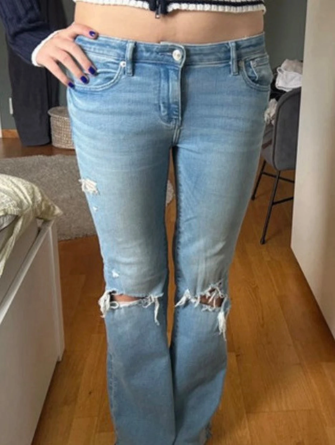 Ljusblå slitna bootcut jeans